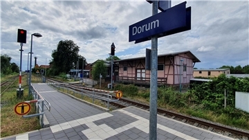 Eisenbahngleise und ein Gebäude im Hintergrund. Im Bild zu sehen ist der Bahnhof Dorum.  