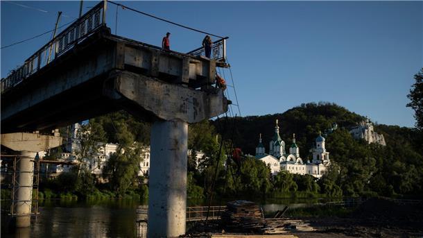 Krieg gegen die Ukraine: So ist die Lage Bauarbeiter steigen von einer Leiter auf einer zerstörten Brücke neben dem Kloster Swjatohirsk herunter.
