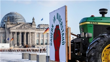 Protest für Agrarwende - Appell für Kampf gegen Hunger „Bauern im Widerstand“ - Ein Traktor fährt am Reichstaggebäude in Berlin vorbei.