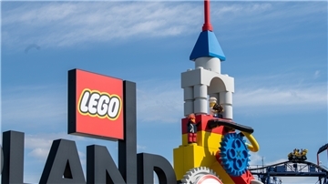 Neben dem Logo am Eingang zum Legoland ist eine Achterbahn zu sehen.