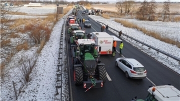Traktoren und andere Fahrzeuge auf einer winterlichen Straße