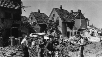 Menschen auf einem Schwarz-Weiß-Bild in einer Trümmerlandschaft. Am 18. Juni 1944 fielen Bomben auf Nordenham.