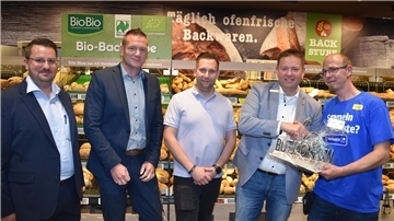 Das Foto zeigt fünf Männer im neuen Netto-Markt in Burhave.