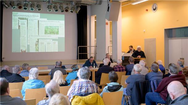 Publikum schaut bei einem Vortrag auf die Leinwand.