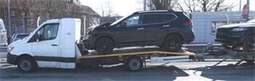 Ein Lkw, der mit einem Auto beladen ist und einen ebenfalls mit Auto beladenen Anhänger zieht. Der Lkw wurde von der Polizei wegen erheblicher Schäden aus dem Verkehr gezogen.