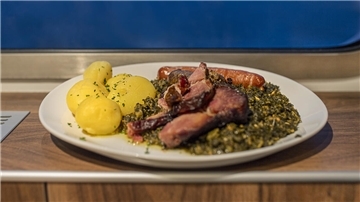 Eine Portion Grünkohl mit Kartoffeln und Wurst. 
