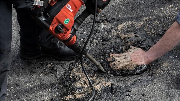 Bei einer Blockade der Gruppe Letzte Generation auf der Stadtautobahn unweit des Kurfürstendamms in Berlin wird ein Aktivist, der sich mit einem besonderen Gemisch auf die Straße festgeklebt hatte, mit schwerem Gerät von der Polizei von der Straße gelöst.