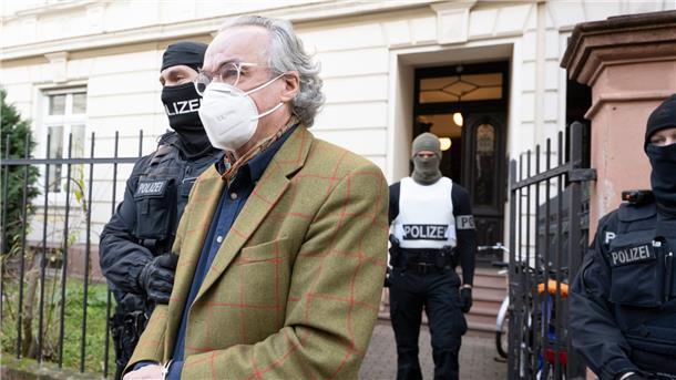 Ein „Rädelsführer“ und die „Reichsbürger“ in Thüringen Bei einer Razzia gegen sogenannte Reichsbürger führen Polizisten Heinrich XIII Prinz Reuß (vorn) zu einem Polizeifahrzeug.