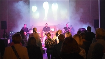 Musiker auf einer Bühne vor Publikum
