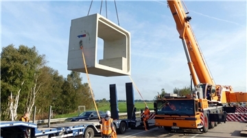 Bei Nordholz wird derzeit der Durchlass für den Altenbrucher Kanal erneuert. Dabei werden Betonteile durch die teilweise geöffnete Fahrbahn eingepasst. 