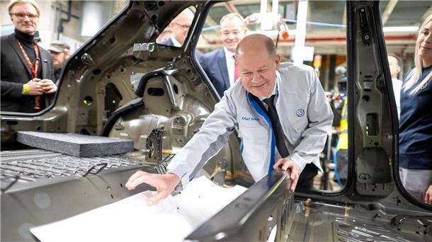 „Elektromobilität funktioniert“ - Kanzler besucht VW Emden Bei seinem Besuch im Emder VW Werk hilft Bundeskanzler Olaf Scholz (SPD) beim Einbau einer Dämmmatte.