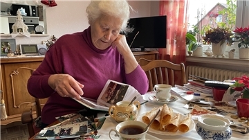 Bei Tee und Krollkuchen blättert Lotte Görries in einem alten Fotoalbum. Viele Erinnerungen werden dabei wach.