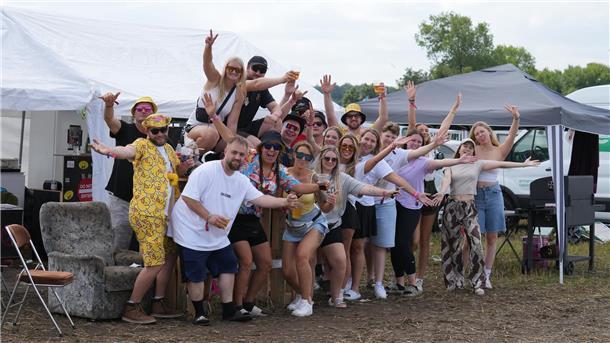 Eine Gruppe von Menschen steht auf dem Zeltplatz des Deichbrand-Festivals 2025 im Kreis Cuxhaven.
