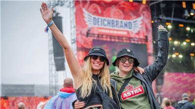Zwei Frauen posieren vor einer Deichbrand-Bühne.
