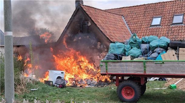 Unrat vor einem Haus steht in Flammen.