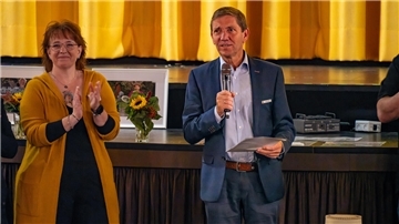 Eine Frau und ein Mann stehen vor einer Bühne. Beim Welthospiztag in Brake stand die Verbindung von Ernst und Heiterkeit im Mittelpunkt – organisiert von der Diakonie Wesermarsch.. Zu Gast war der stellvertretende Landrat Dieter Kohlmann.