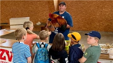 Benjamin Penny zeigte den Kindern einen New-Hampshire-Hahn. Die ausgeglichenen Tiere werden schnell zahm.