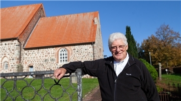 Pastor Bernd Passarge steht vor der Midlumer Kirche
