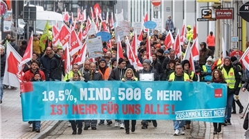 Teilnehmer einer Demonstration zeigen während eines Warnstreiks auf einem Transparent mit der Aufschrift «10,5 Prozent, mindestens 500 Euro mehr ist mehr für Alle!» ihre zentralen Forderungen. 