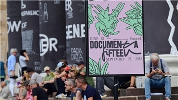 Besucher der documenta fifteen sitzen auf den Stufen des Fridericianums in Kassel.