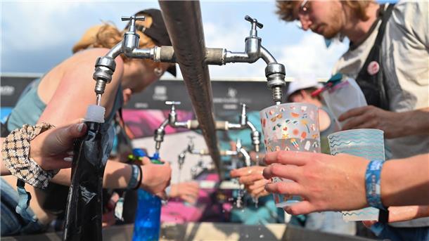 Besucher füllen beim Hurricane Festival ihre Becher und Trinkflaschen mit Wasser auf. In Deutschland steigen die Temperaturen - und die Ozon-Werte.
