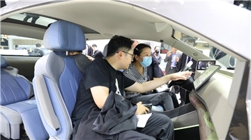 Besucher probieren ein HarmonyOS-basiertes intelligentes Bordcomputerterminal am Huawei-Stand auf der 20. internationalen Automobilausstellung „Auto Shanghai 2023“.