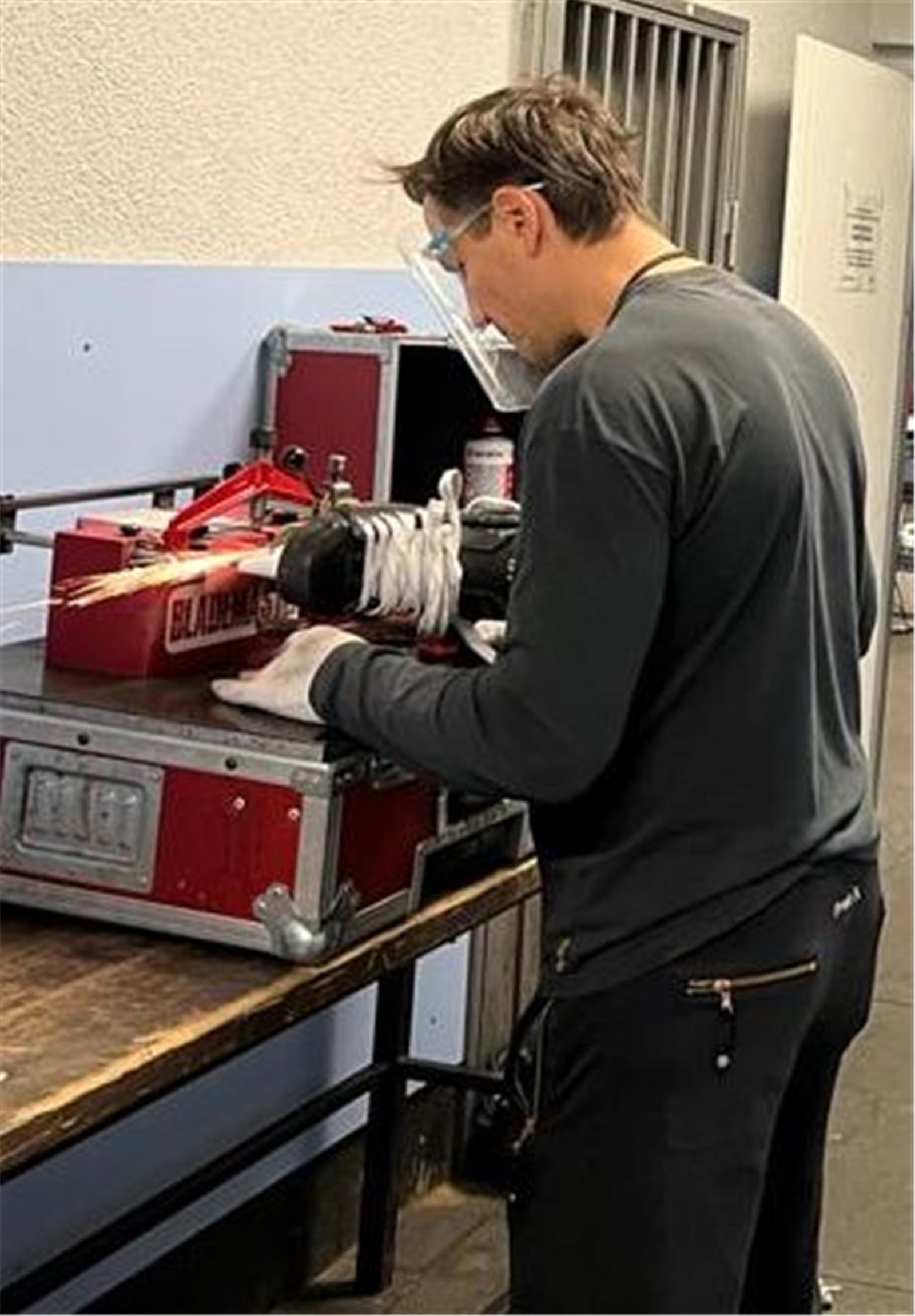 Betreuer Andrej Teljukin an der Schleifmaschine.