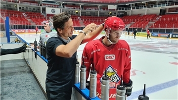 Betreuer Andrej Teljukin schraubt am Helm von Christian Wejse.