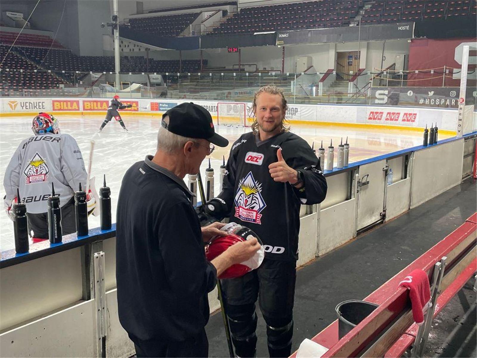 Betreuer Ralf Schreuder putzt das Visier von Kapitän Mike Moore.