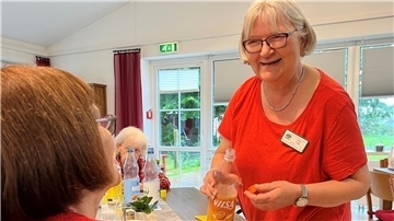 Eine Frau schenkt Sprudel ein. 