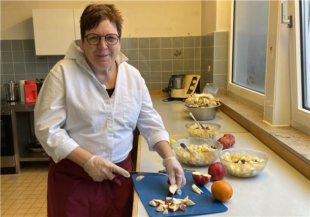 Eine Frau zerschneidet einen Apfel in kleine Stücke.