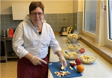 Eine Frau zerschneidet einen Apfel in kleine Stücke.