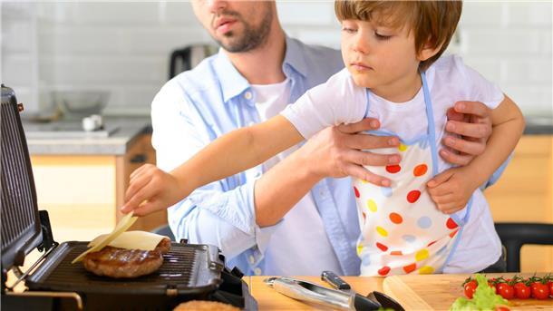 Gesunder Körper, gesunder Geist – wie Eltern ihren Kindern dabei helfen können Vater mit Kind am Kochen