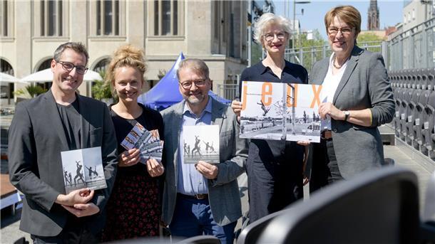 Fünf Personen, zwei Männer und drei Frauen, halten Flyer und ein Plakat in die Kamera.