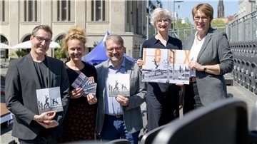 Fünf Personen, zwei Männer und drei Frauen, halten Flyer und ein Plakat in die Kamera.