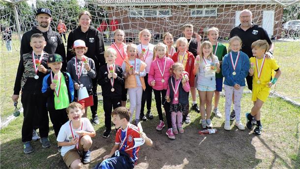 Viele Kinder halten stolz ihre Medaille der Kinderolympiade in die Kamera.