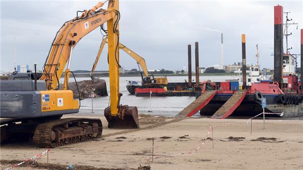 Ein Bagger steht am Strand