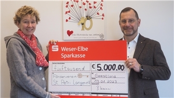 Steuerberaterin Bettina Summa übergibt den symbolischen Spendenscheck an Alexander Thorau, den Vorsitzenden des Fördervereins des St. Petri Kindergartens „Arche Noah“