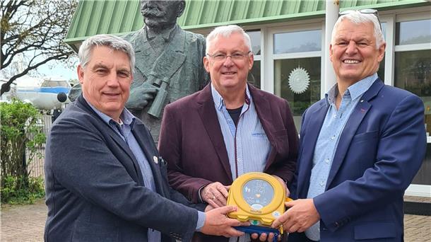 die Präsidenten des Rotary-Clubs Cuxhaven und Rotary-Clubs Otterndorf-Land Hadeln, Uwe Leonhardt und Friedhelm Engelke übergeben einen Defibrillator an den kaufmännischen Leiter des Aeronauticums, Hans-Peter Weber
