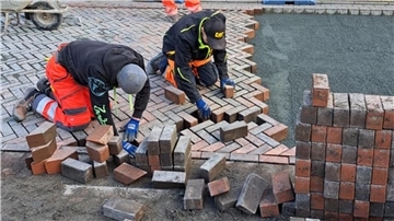 Mitarbeiter der Firma Stehnke Bauunternehmung aus Osterholz-Scharmbeck verlegen das Pflaster an der Piazza in Hagen neu. 