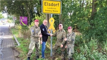 Spieß Andreas Stühlmeyer, Organisator des Toy Drop, zwei Soldaten und Elsdorfs Bürgermeister Andreas Bellmann.  
