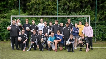Mannschaftsfoto der Handicap-Fußballer des OSC Bremerhaven mit neuen schwarzen Trainingsanzügen der Gewoba