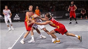 Basketballer ringen um den Ball.