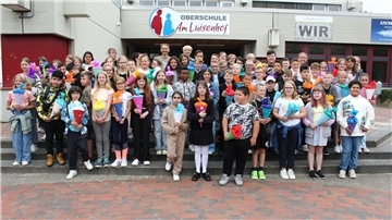 Viele Jungen und Mädchen stehen mit Schultüten vor dem Schulgebäude.