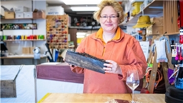Eine Frau hält ein Stück Holz in den Händen