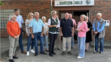Mehrere Menschen bei einer Spendenübergabe vor dem Eingang der Schützenhalle