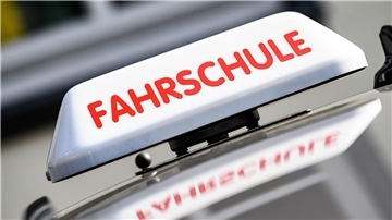 Fahrschulschild auf einem Autodach.