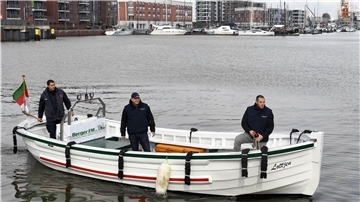 Ein Börteboot ist in einem Hafen unterwegs