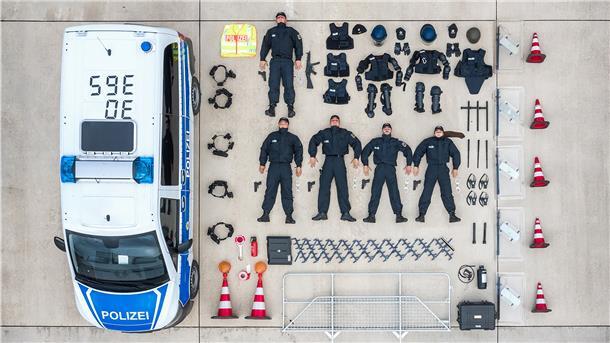 Neben einem Polizeiauto sind alle Gegenstände ordentlich aufgereiht.