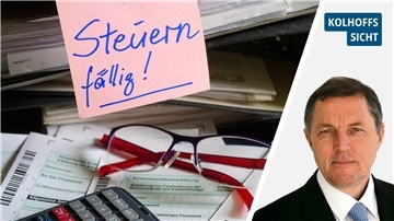 Steuerformulare, Belege sowie Brille und Taschenrechner liegen auf einem Tisch.